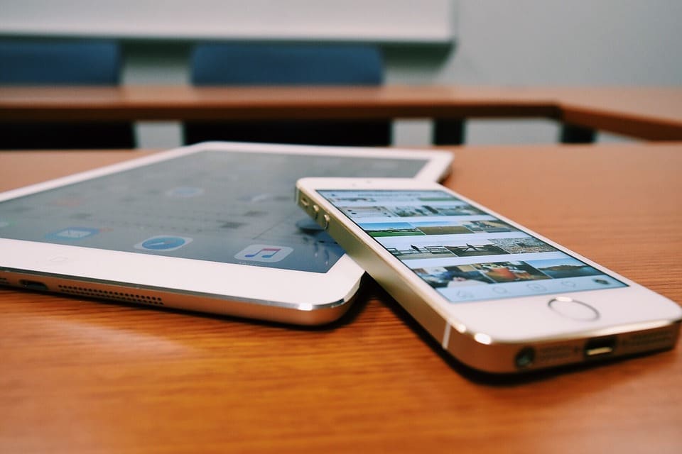 phone and tablet device sit on table