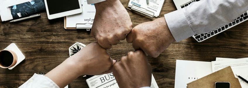 Department Integration & Optimization Part 5: Finance 24 four people fist bump over desk