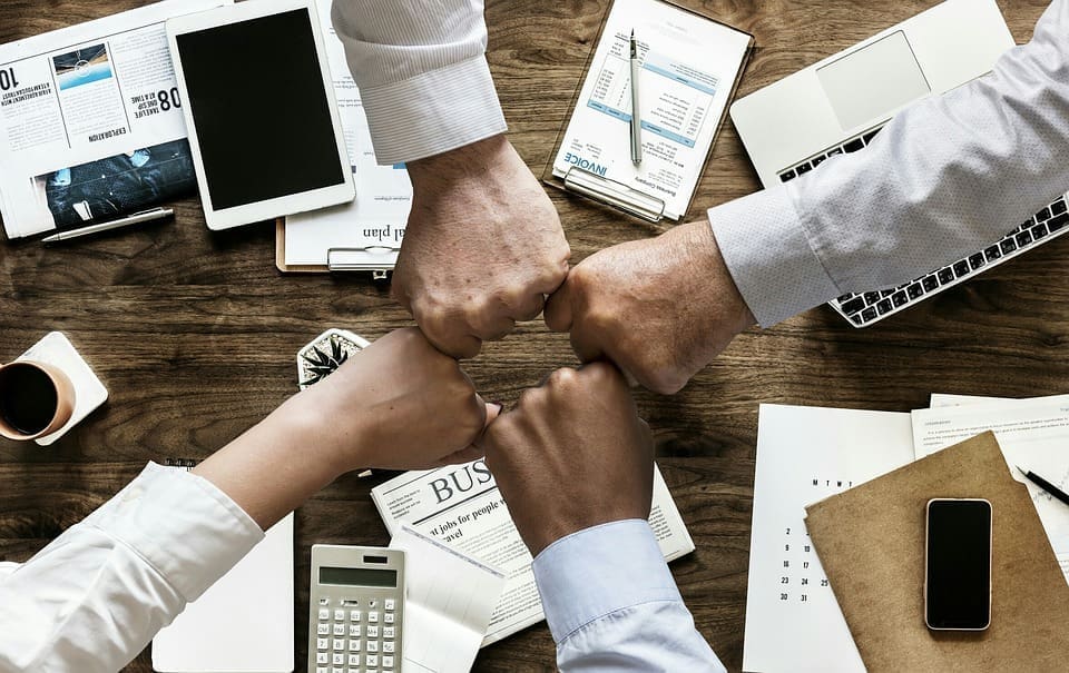 Resources 137 four people fist bump over desk