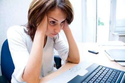 Resources 75 businesswoman holding head in her hands stares at laptop